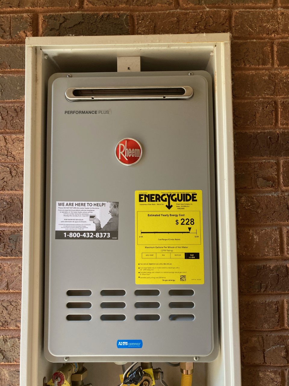 Wall-mounted Rheem tankless water heater on a brick exterior